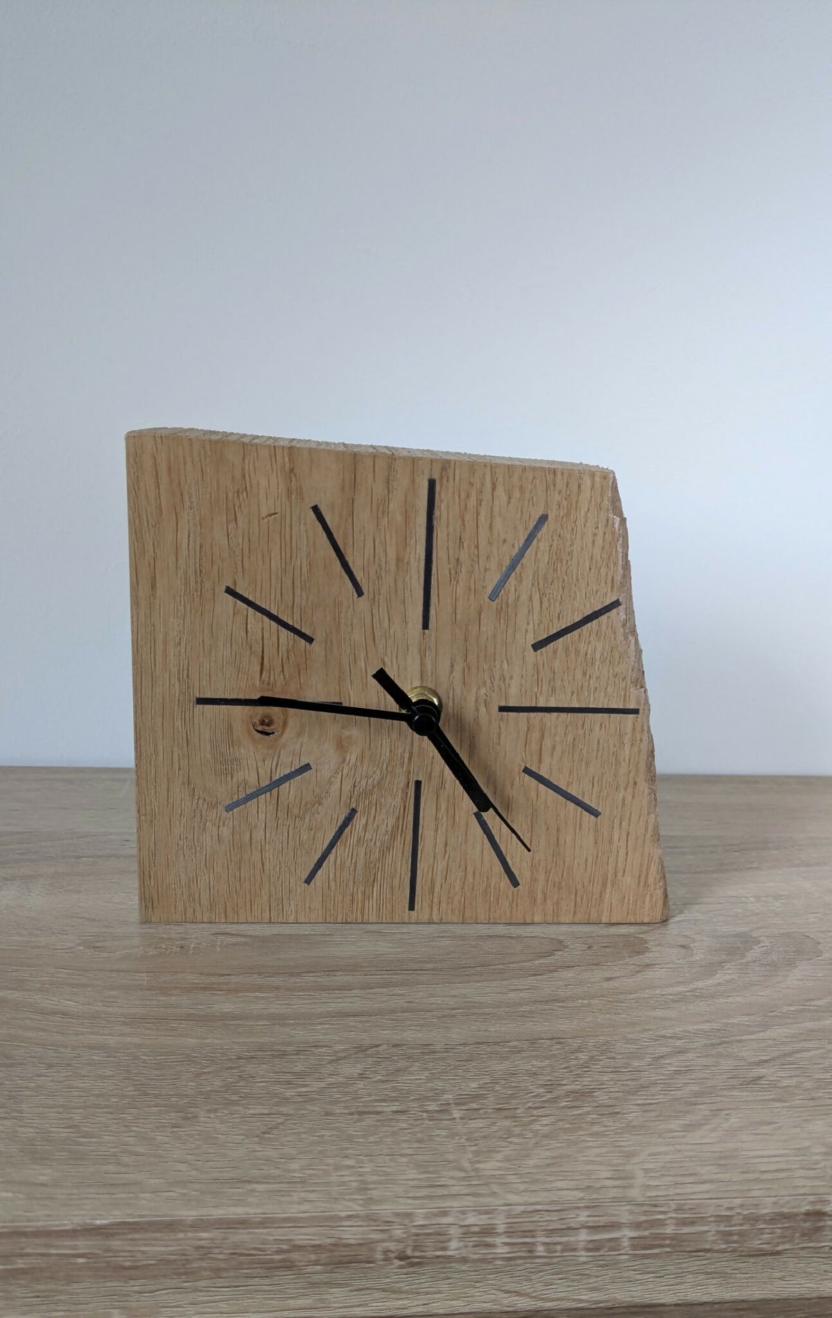 Horloge de bureau en chêne, cadran à repères noirs, aiguilles dorées.