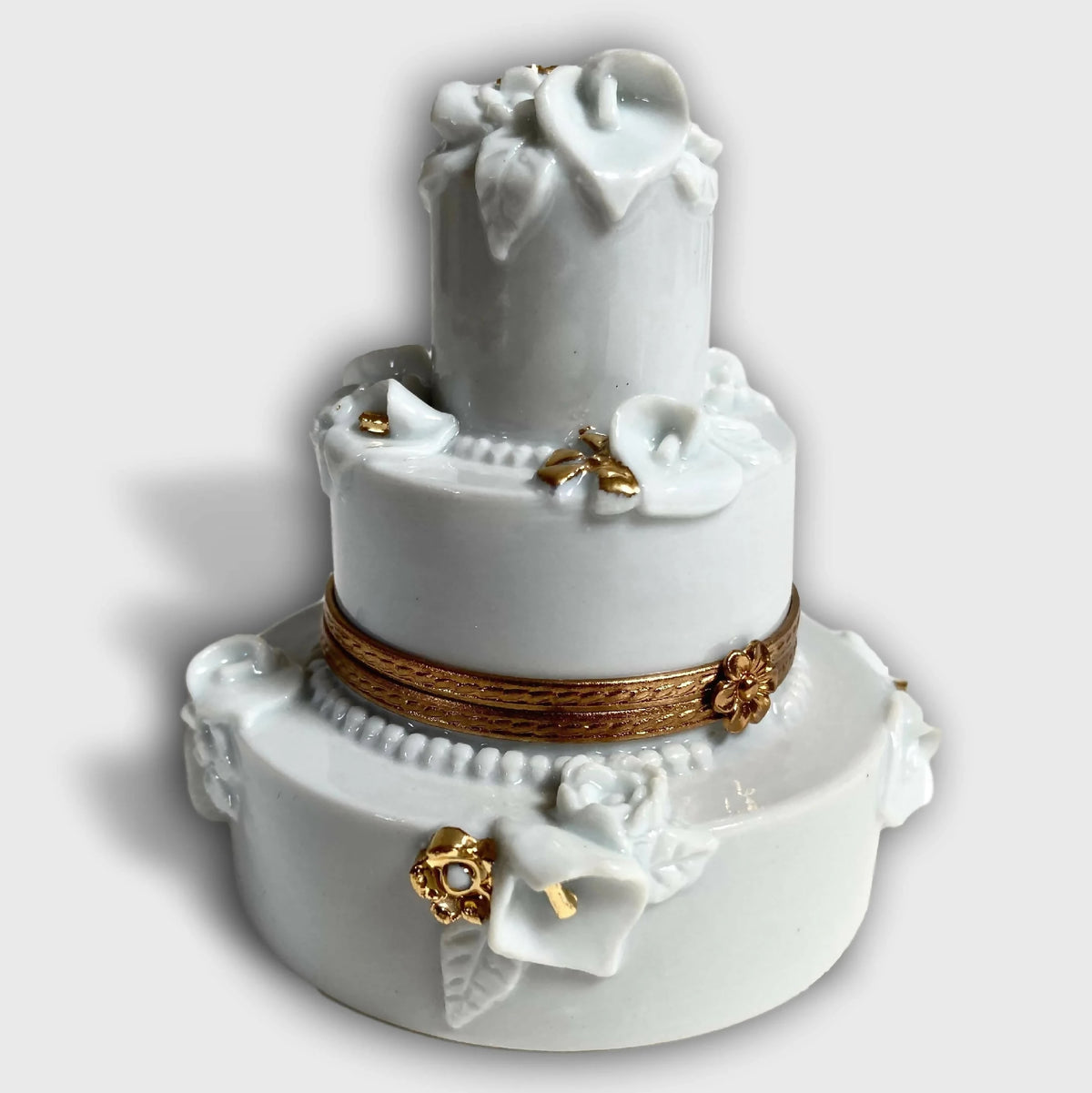 Boîte en porcelaine blanche, décor floral en relief et nœuds, bordure dorée.