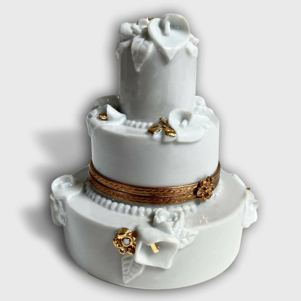 Boîte en porcelaine blanche, décor floral en relief et nœuds, bordure dorée.