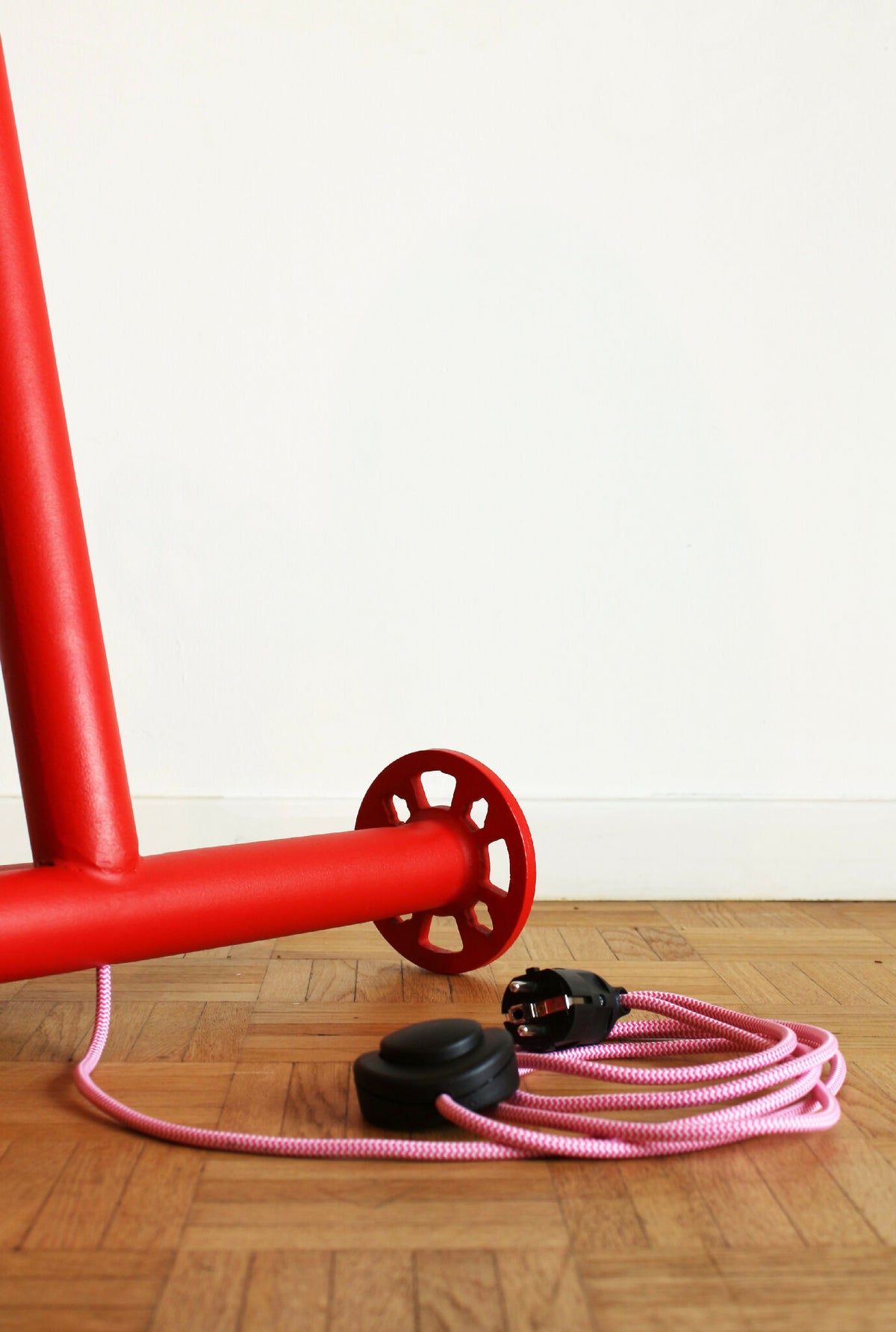 Lampe rouge : pied avec disques de fixation et enroulement de câble rose et noir