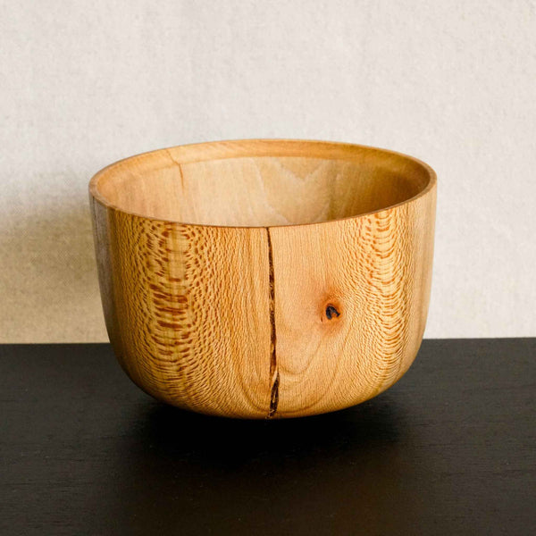 Bol en bois clair avec large nœud sombre et couture verticale centrale