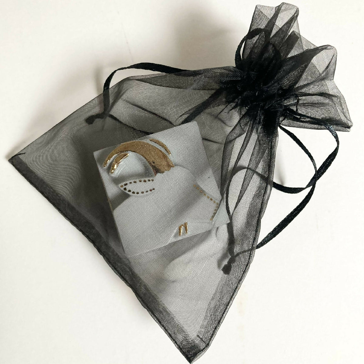 Boîte à bijoux en porcelaine blanche dans un pochon en organza noir, motif capricorne