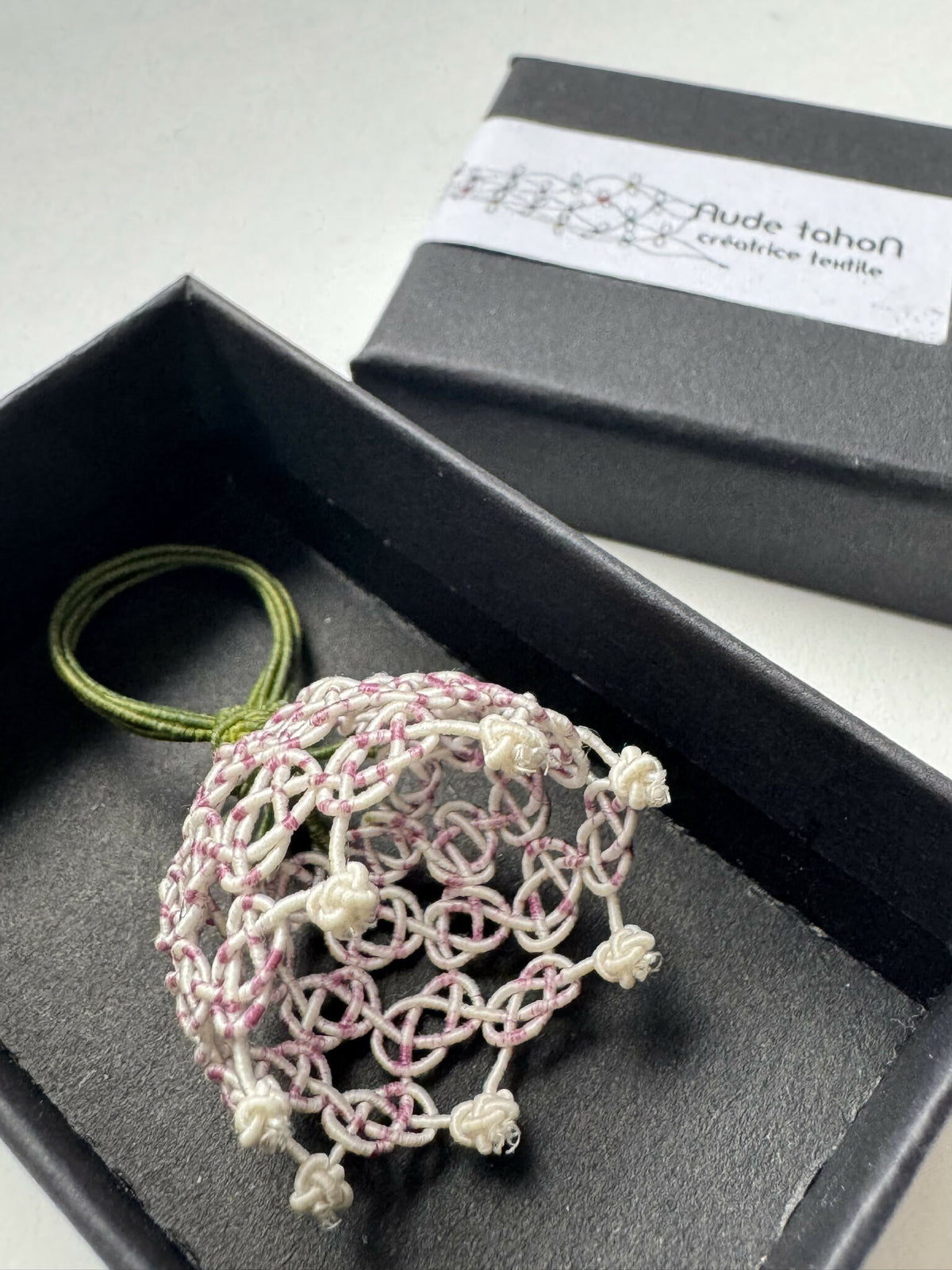 Bague clochette en soie tressée, maille rose et blanc, avec lien vert