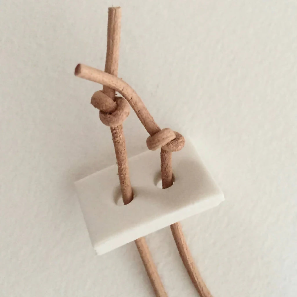 Pendentif avec cordon beige et attache en boucle, vue du fermoir