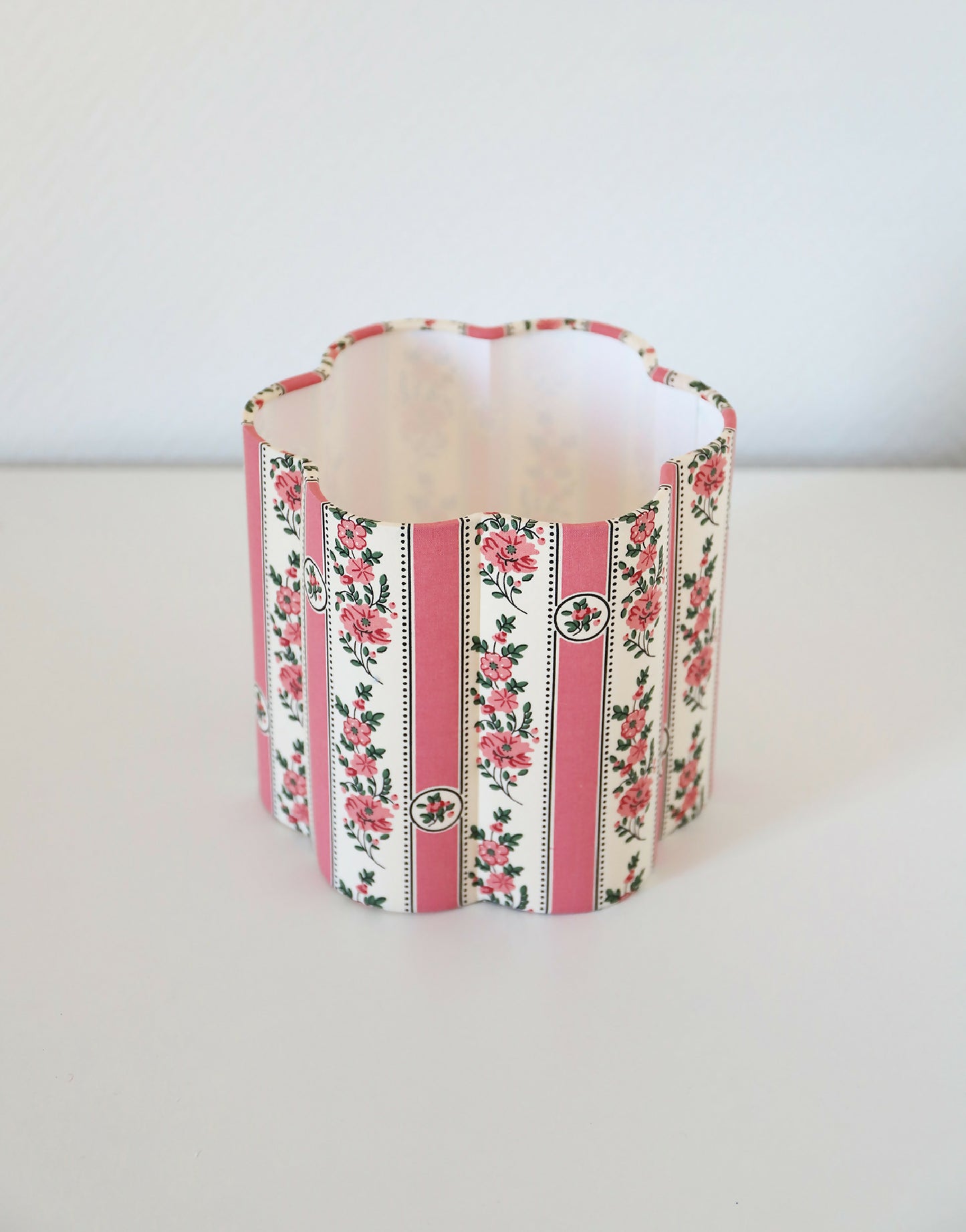 Abat-jour forme fleur en tissu imprimé, rayures verticales roses et fleurs.
