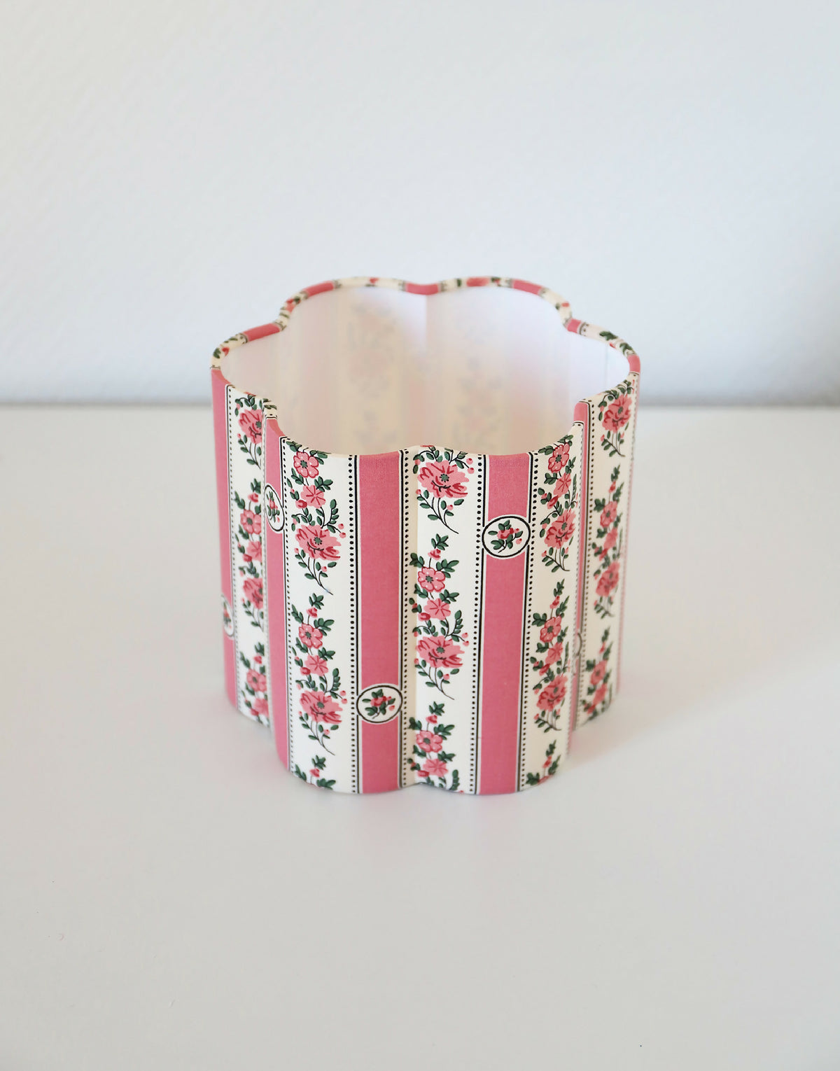 Abat-jour forme fleur en tissu imprimé, rayures verticales roses et fleurs.