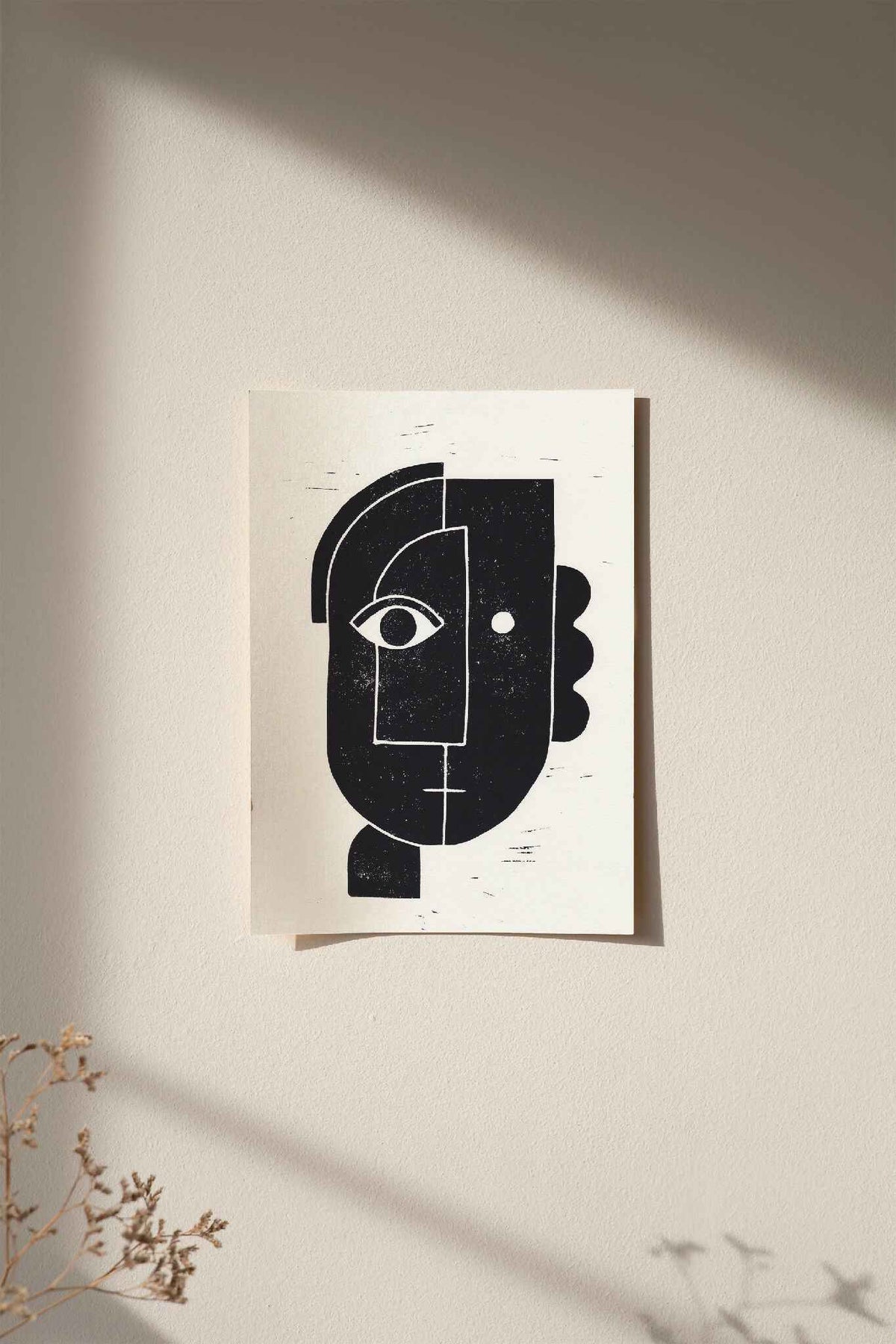 Linogravure encadrée, visage abstrait noir sur fond clair, affiche rectangulaire