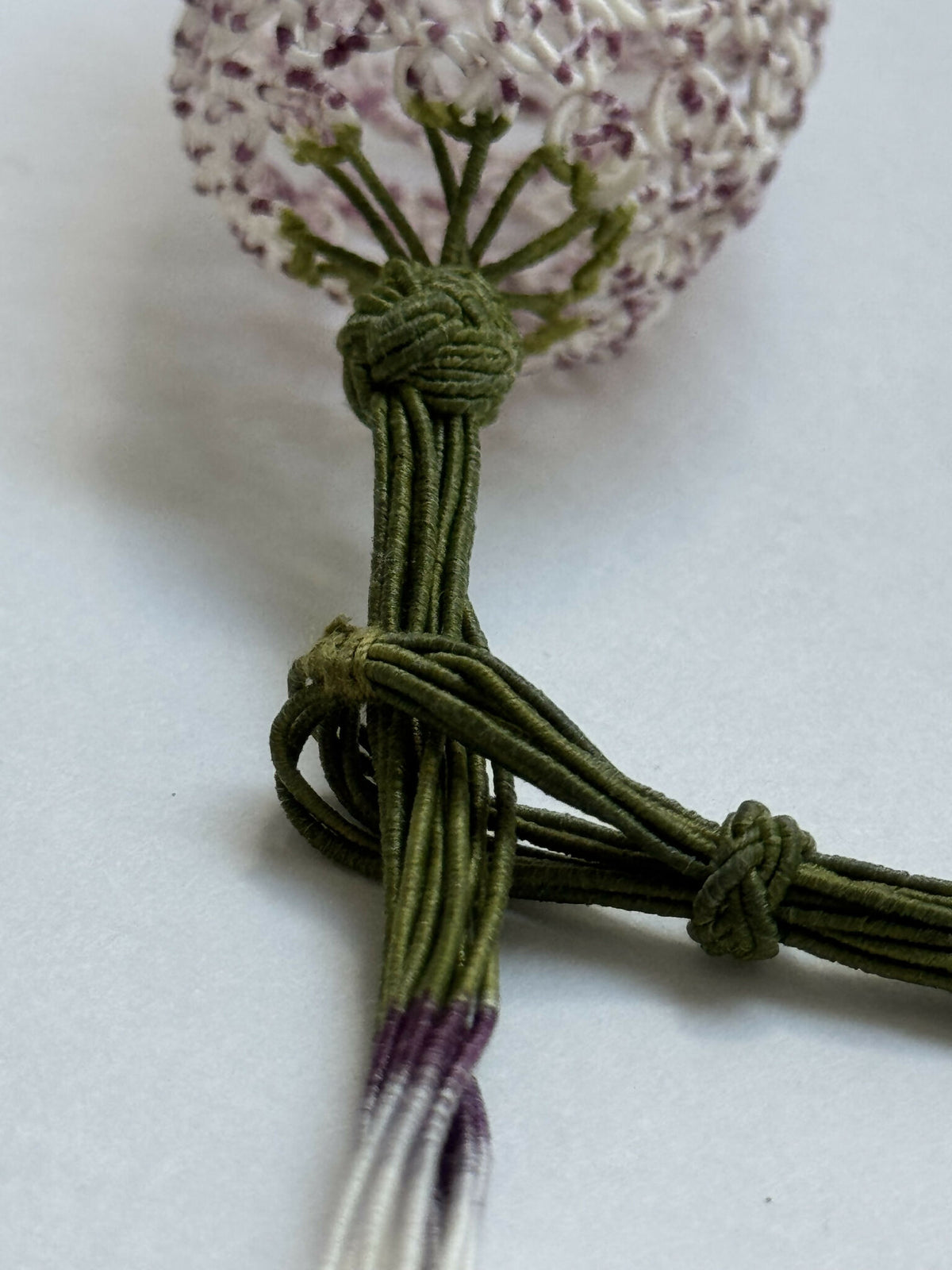 Collier en soie tulipe : nœud torsadé vert et pendentif tissu mauve pailleté.