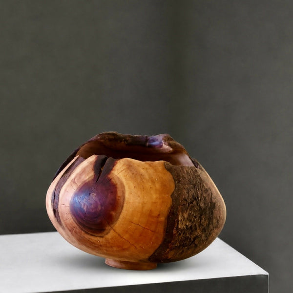 Bol décoratif en bois sculpté, teintes miel et brun foncé, surface texturée.