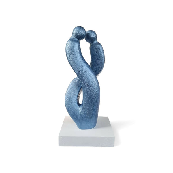 Sculpture couple abstrait en métal bleu, corps enlacés sur socle carré blanc.