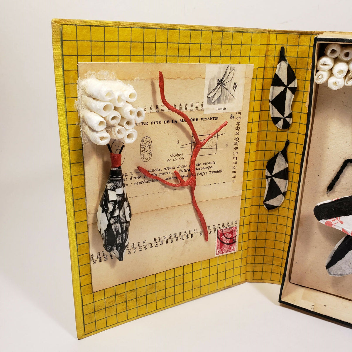 Pages ouvertes : grille jaune et collage d’insecte avec papillons et fragments papier.