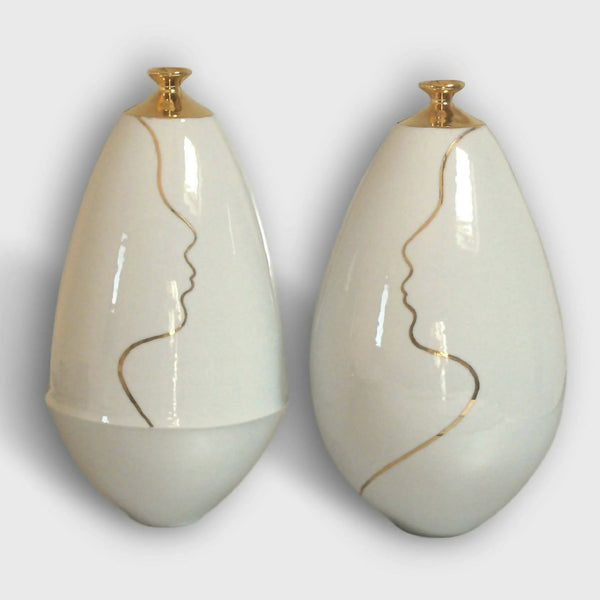 Vase soliflore en céramique blanche, col doré et contour de visage au trait.