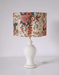 Abat-jour fleuri crème et multicolore, posé sur une lampe blanche avec interrupteur.