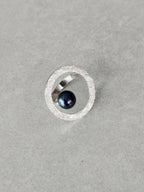 Bague ovale argentée texturée avec cabochon bleu foncé et sertissage ouvert