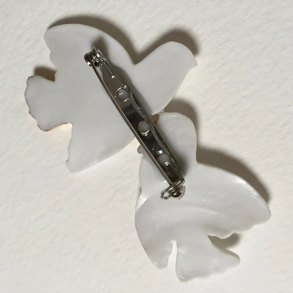 Broche colombes blanche avec épingle et fermoir métallique au dos.