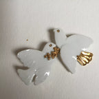 Broche colombes blanches, ailettes sculptées et accents dorés brillants.