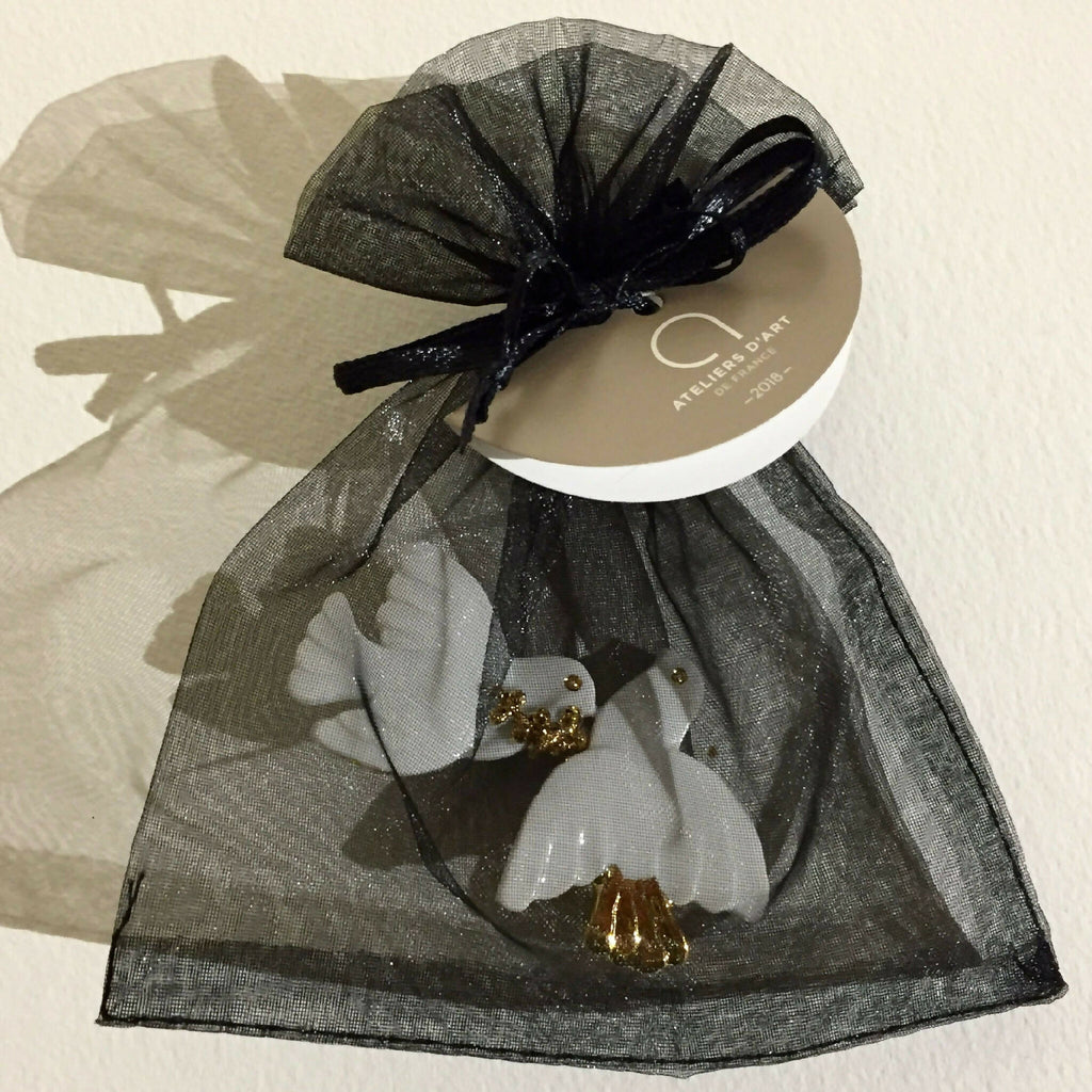 Broche colombes blanches à accents dorés, portée sur sachet en organza.