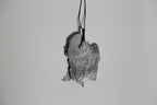 Pendentif gris en forme de feuille d’arbre, vue de trois-quarts, sur cordon.
