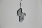 Pendentif gris en forme de feuille, texture nervurée, sur cordon noir.