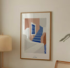 Affiche A4 encadrée, escaliers bleus et façades abstraites beige, gris et terracotta.