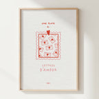 Affiche encadrée avec illustration rouge et texte « Une pluie de lettres d’amour ».