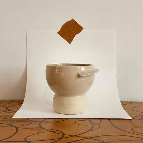 Tasse Bulle en céramique beige, forme arrondie et anse courbe.