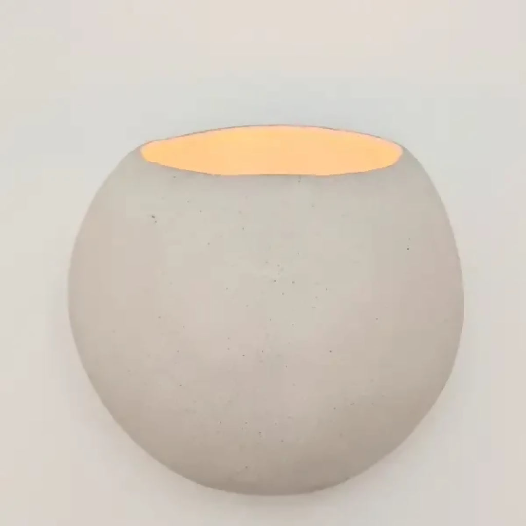 Applique en céramique ronde grise avec insert lumineux orange en demi-lune