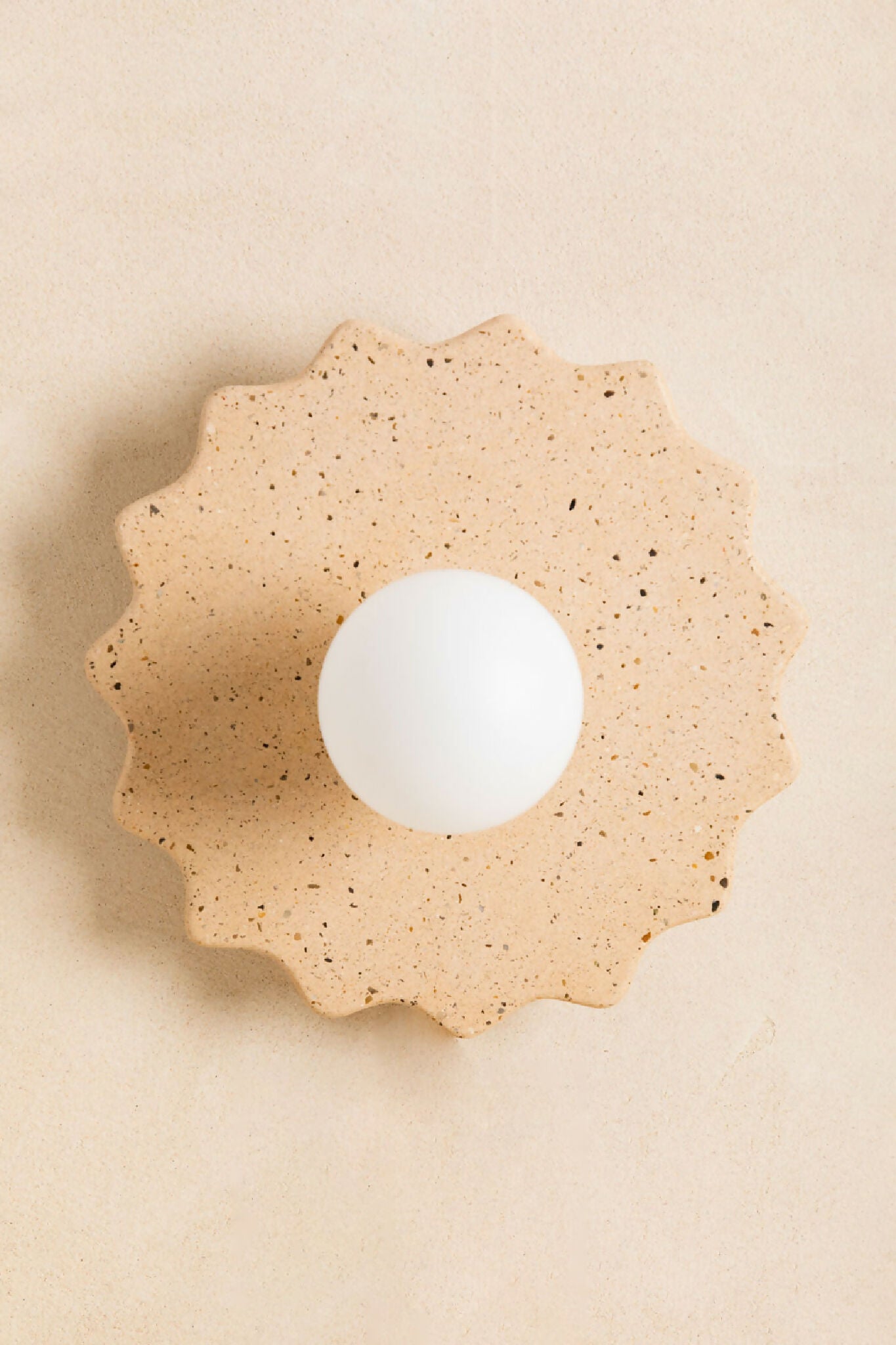 Applique murale taille M beige sable, rosace décorative avec ouverture ronde blanche.