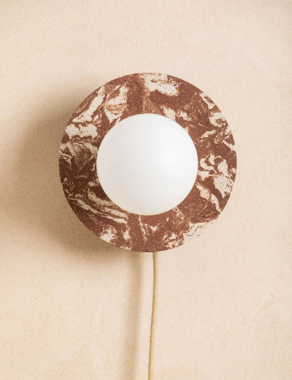 Applique murale ronde brun moucheté avec ouverture centrale et ampoule blanche, câble beige