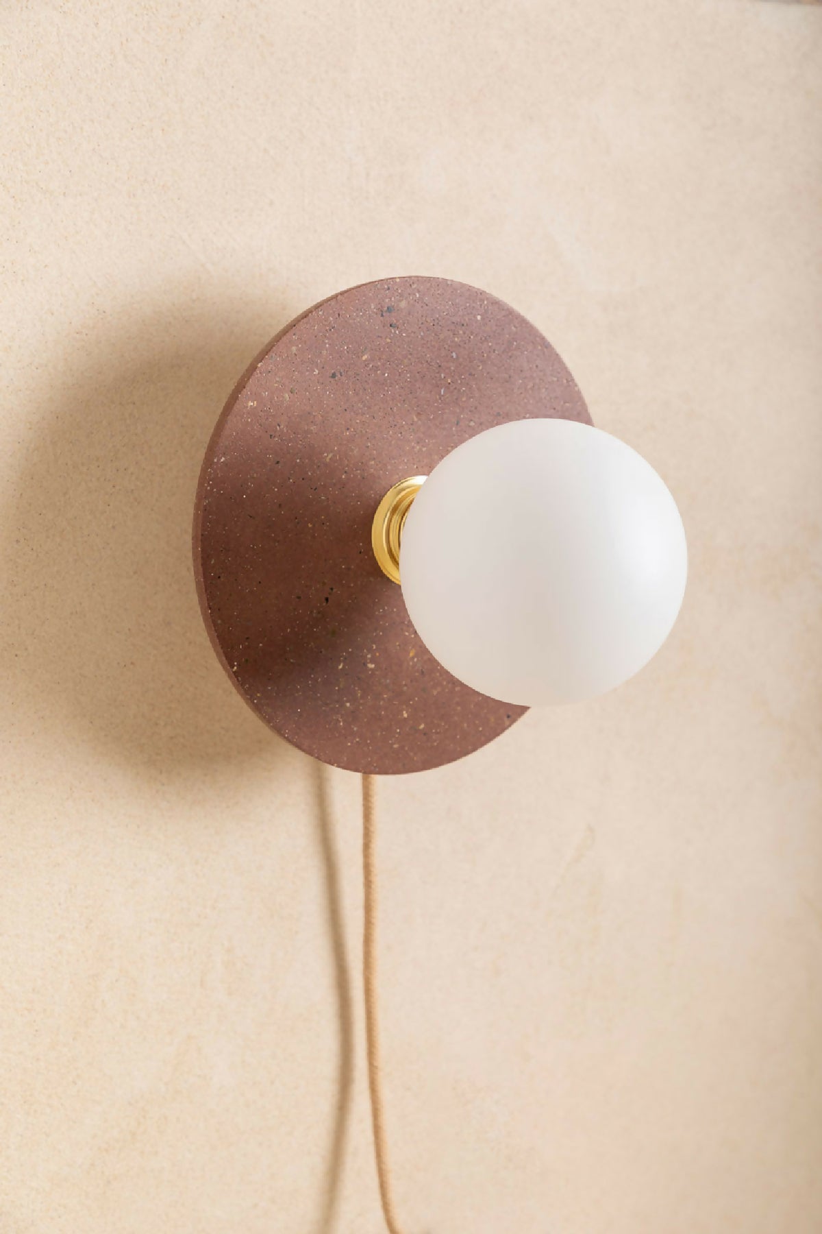 Applique murale ronde brun moucheté avec ouverture centrale et ampoule blanche, douille dorée