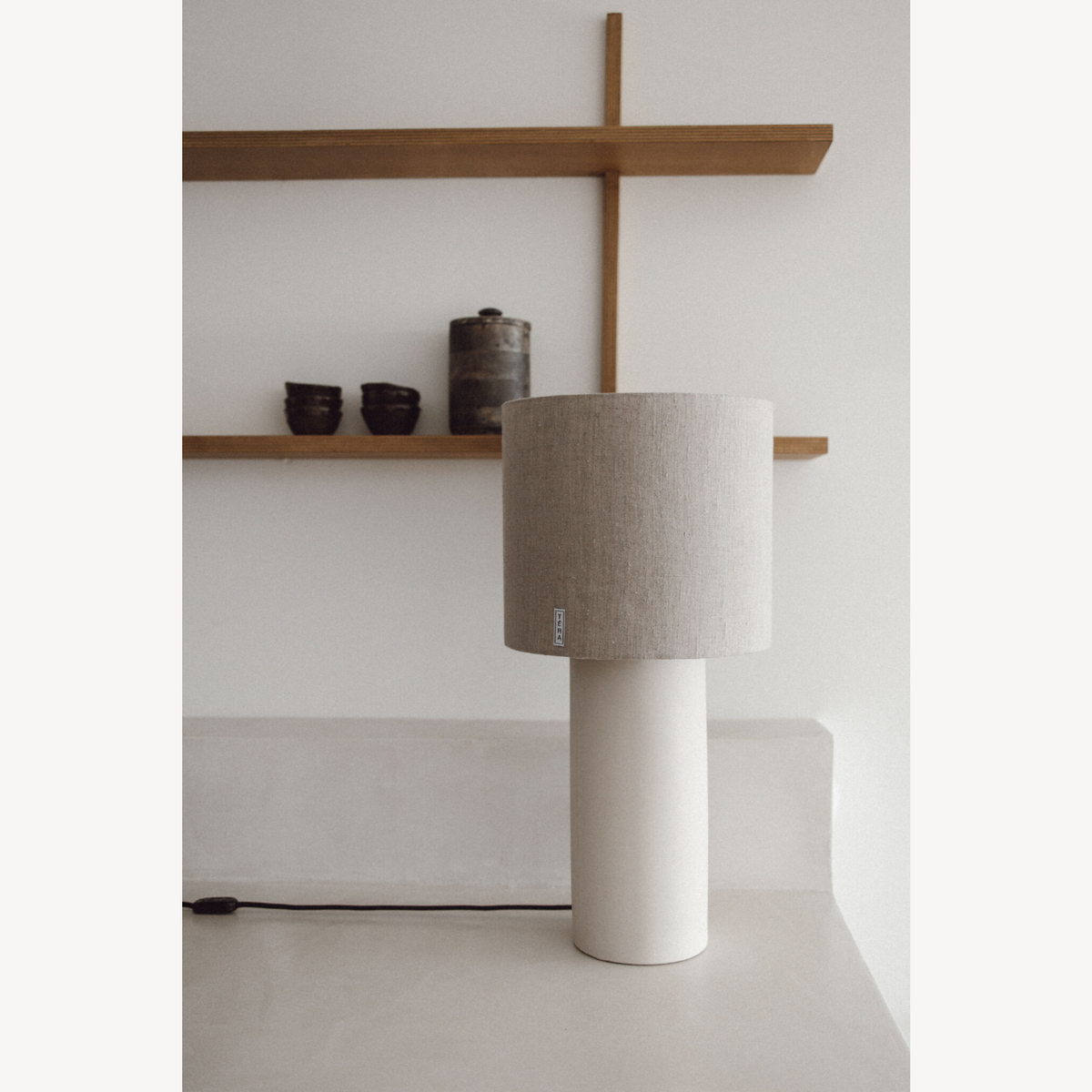 Lampe TERA avec base cylindrique en céramique blanche et abat-jour en tissu beige