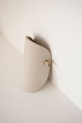 Applique murale en céramique beige, forme arrondie, fixation avec bouton en bois