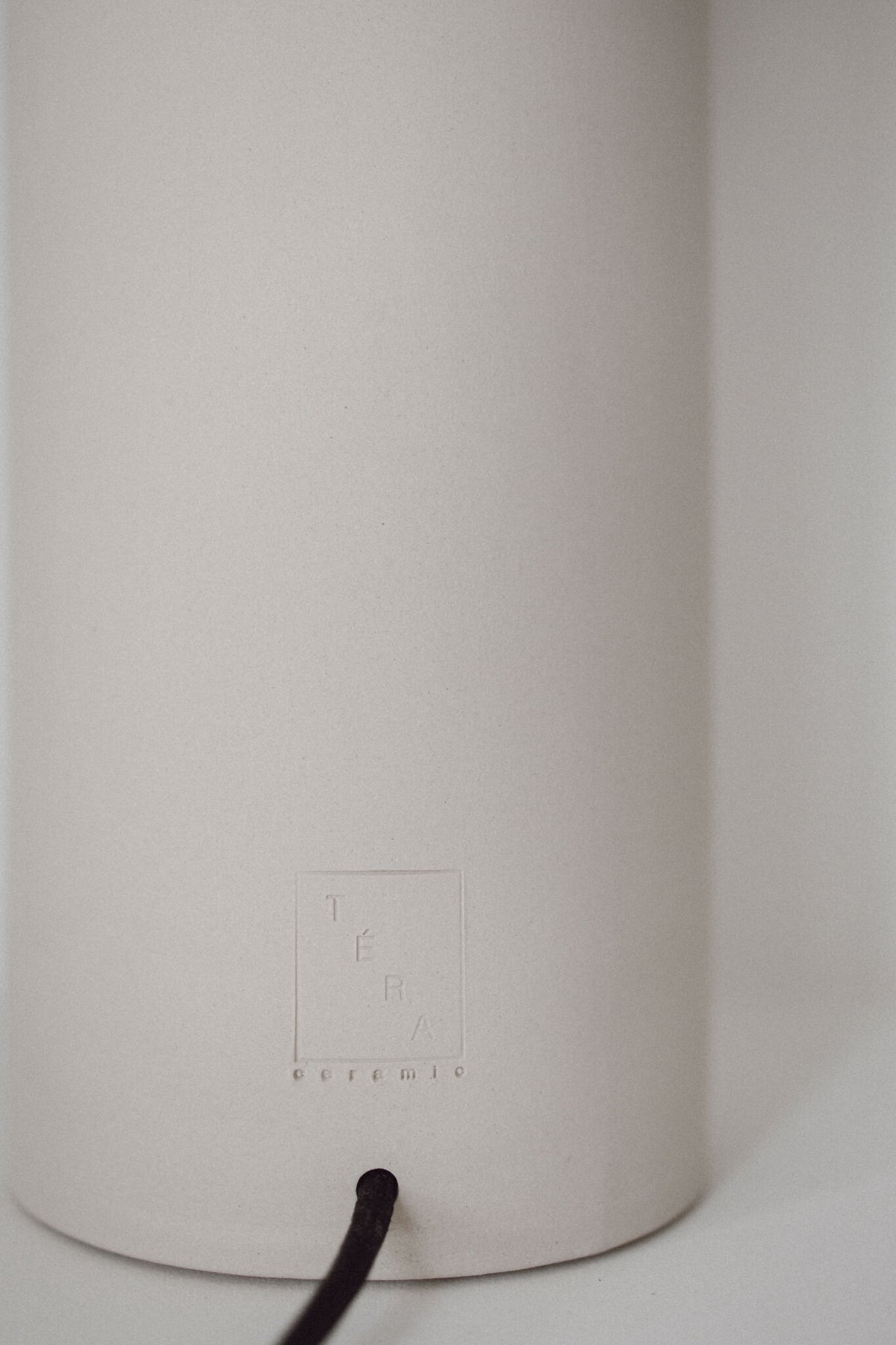Base en céramique blanche de la lampe TERA avec câble noir, vue rapprochée