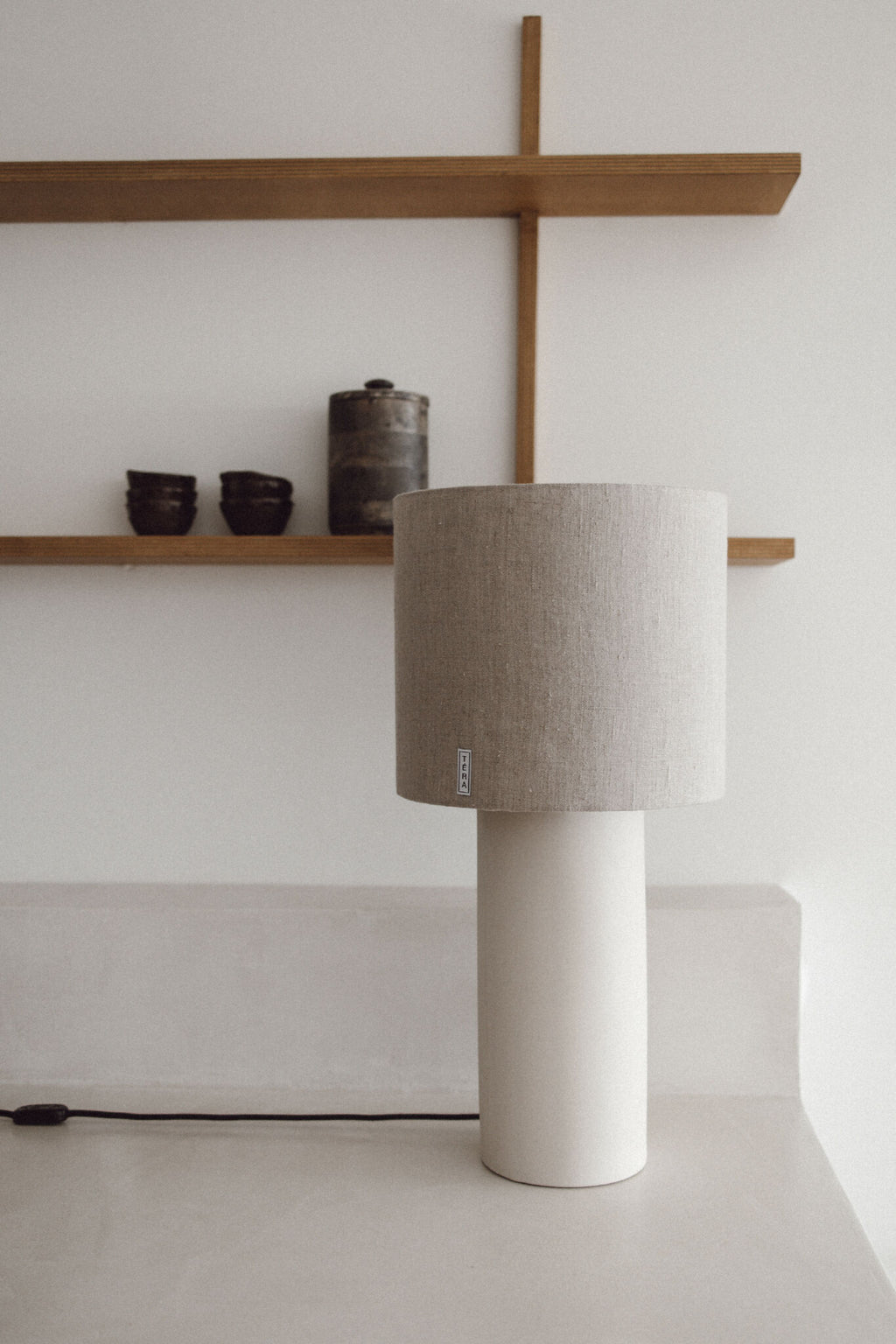 Lampe TERA avec base cylindrique en céramique blanche et abat-jour en tissu beige