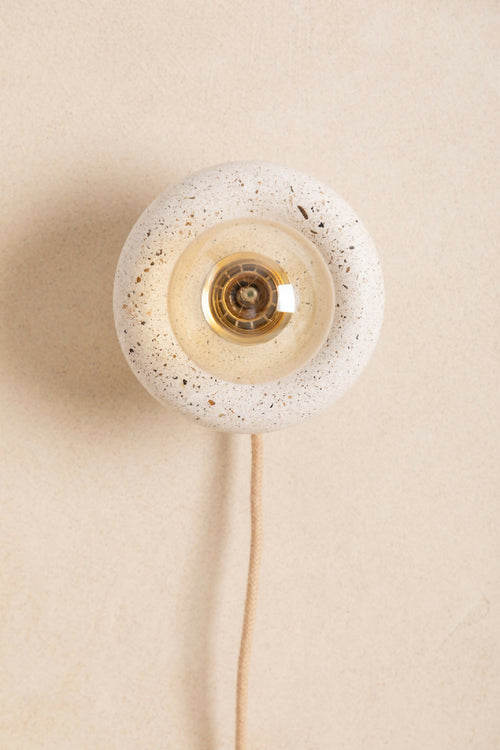 Applique murale ronde en verre texturé beige, douille centrale dorée, câble visible