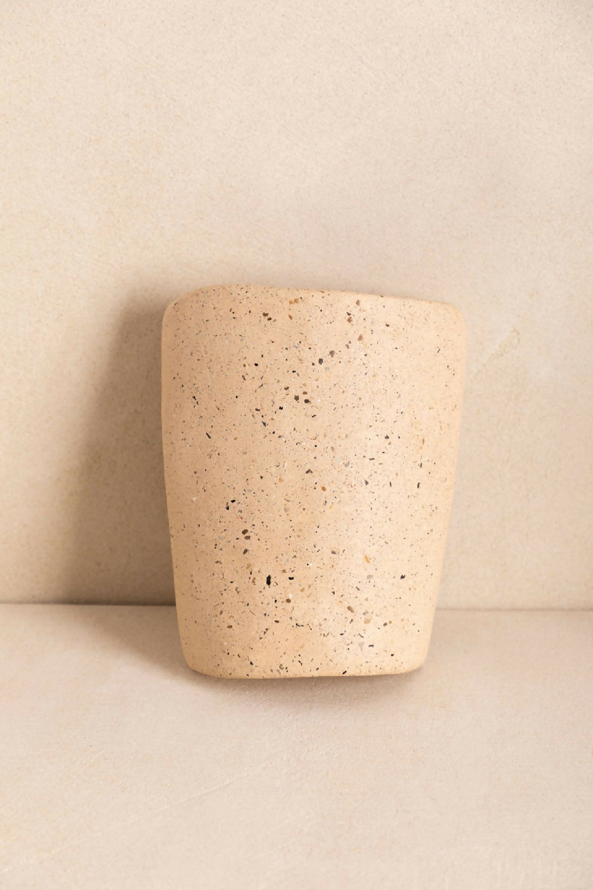 Tuile cylindre en béton beige clair texturé, surface granuleuse