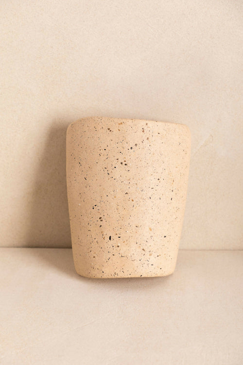 Tuile cylindre en béton beige clair texturé, surface granuleuse