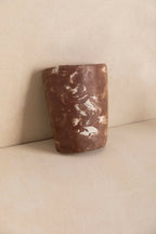 Tuile cylindre en béton marron foncé texturé, surface irrégulière