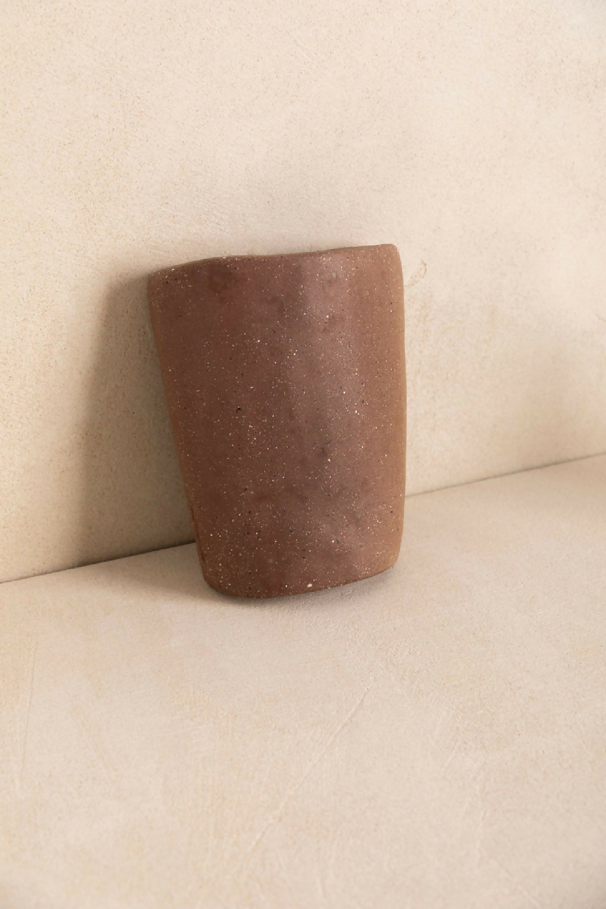 Tuile cylindre en béton marron foncé texturé avec points