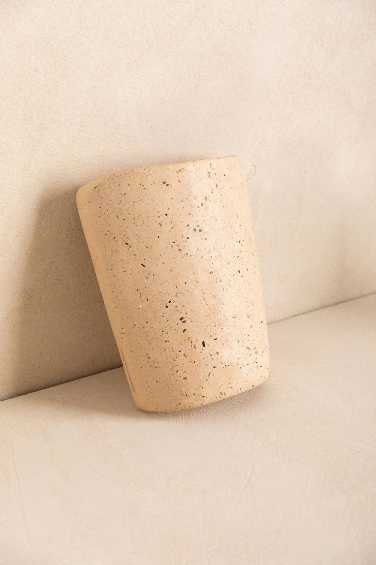 Tuile cylindre en béton beige clair texturé, vue en biais