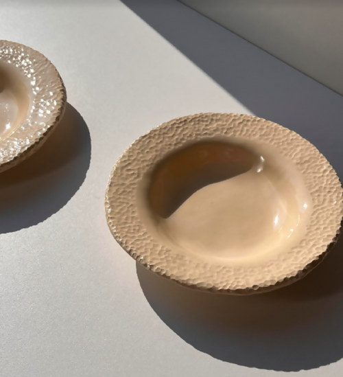 Assiette beige texturée, bord dentelé, vue rapprochée
