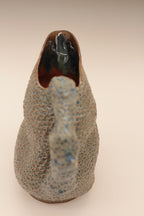 Pichet en céramique bleu moucheté, vue arrière du canard et base stable.
