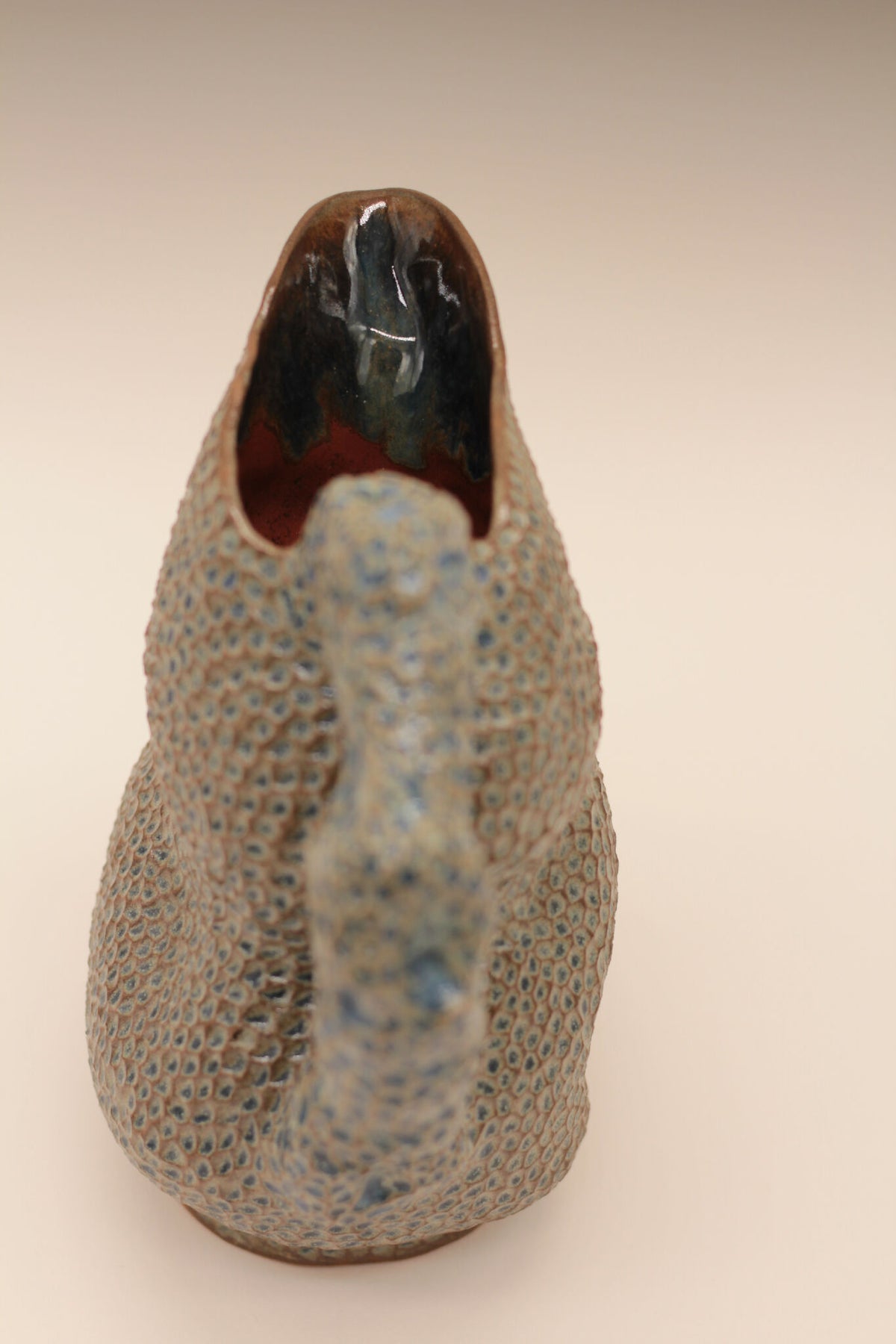 Pichet en céramique bleu moucheté, vue arrière du canard et base stable.