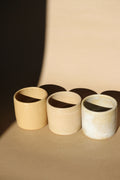 Ensemble de 3 tasses à expresso en céramique beige, finition mate et bords foncés.