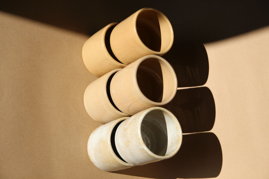3 tasses à expresso en céramique beige et nacré, empilées, vues de dessus.