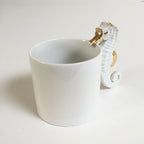 Tasse blanche avec hippocampe doré en relief et petit crochet