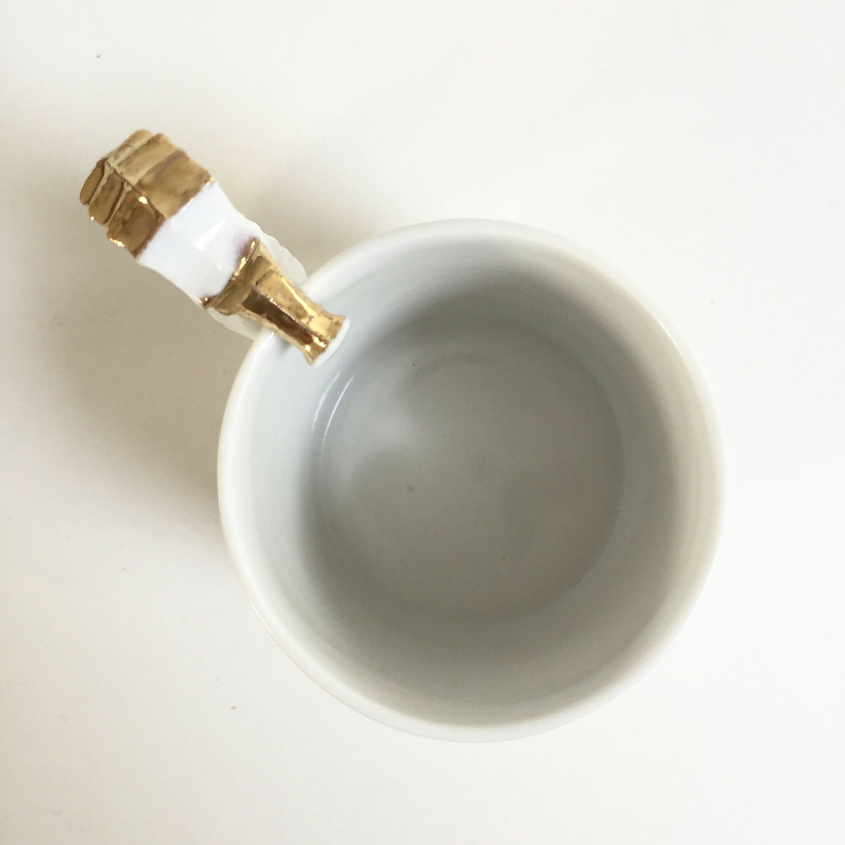 Tasse blanche vue de dessus, hippocampe doré et blanc sur l’anse
