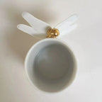 Tasse blanche avec décor libellule doré sur la cuvette, ailes ouvertes