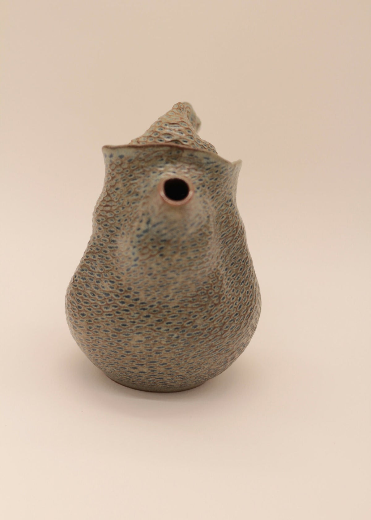 Théière en céramique grise à texture, vue de dessus avec trou de versement