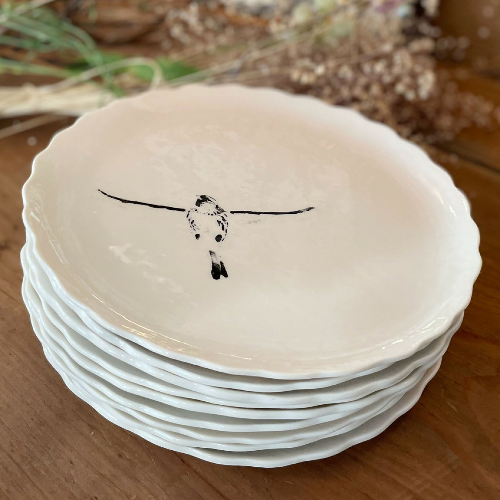 Assiette à dessert en porcelaine blanche, bord festonné, oiseau noir peint au centre